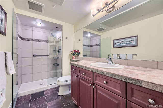 full bathroom featuring vanity, toilet, visible vents, and a stall shower