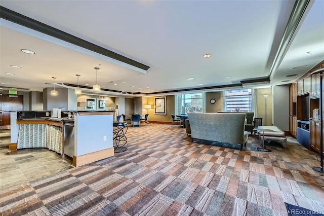 kitchen featuring pendant lighting, an island with sink, recessed lighting, carpet floors, and a breakfast bar area