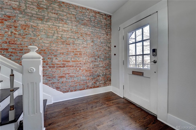 doorway to outside featuring dark hardwood / wood-style floors and brick wall