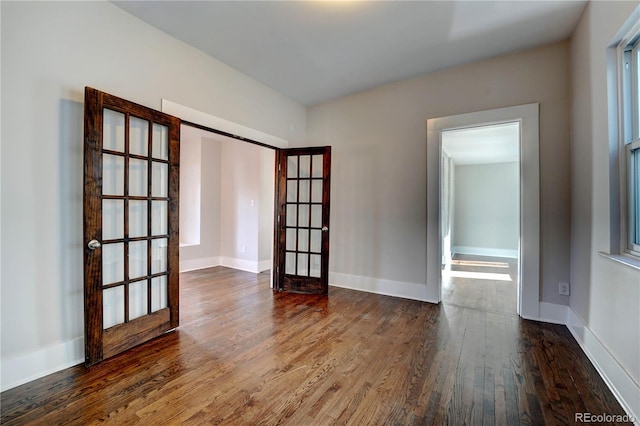 empty room with french doors and dark hardwood / wood-style floors