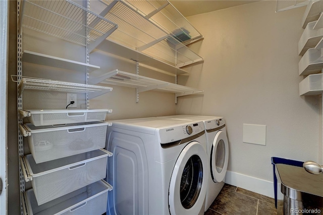 clothes washing area with dark tile patterned floors and independent washer and dryer