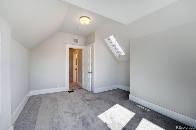 bonus room featuring vaulted ceiling with skylight and light colored carpet