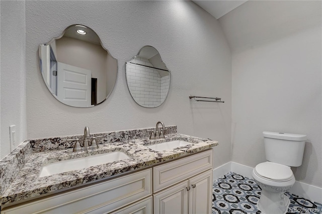 bathroom featuring tile patterned floors, vanity, toilet, and vaulted ceiling