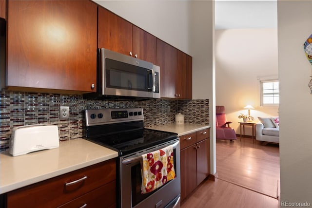 1470 S Quebec Way Unit 245, Denver, CO 80231 - kitchen with appliances with stainless steel finishes, light countertops, light wood-style floors, and tasteful backsplash