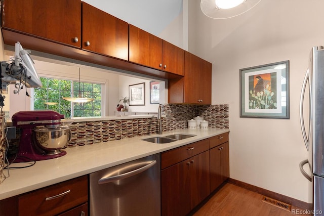 1470 S Quebec Way Unit 245, Denver, CO 80231 - kitchen with stainless steel appliances, a sink, light countertops, light wood-style flooring, and backsplash