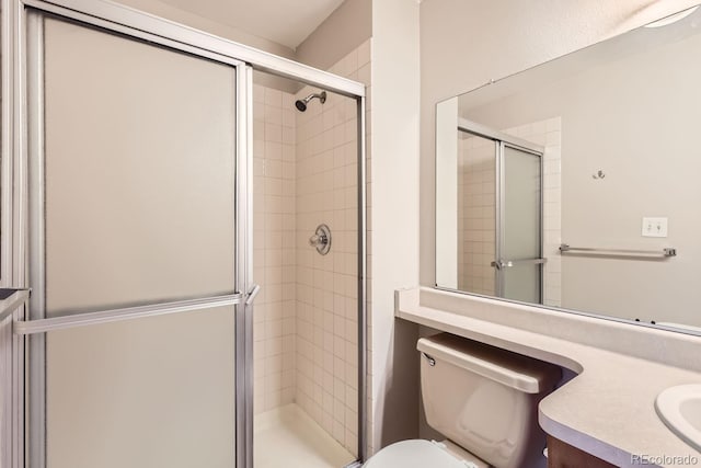 bathroom featuring toilet, an enclosed shower, and vanity