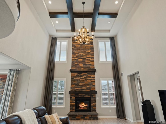 living room with plenty of natural light, a fireplace, coffered ceiling, and a towering ceiling