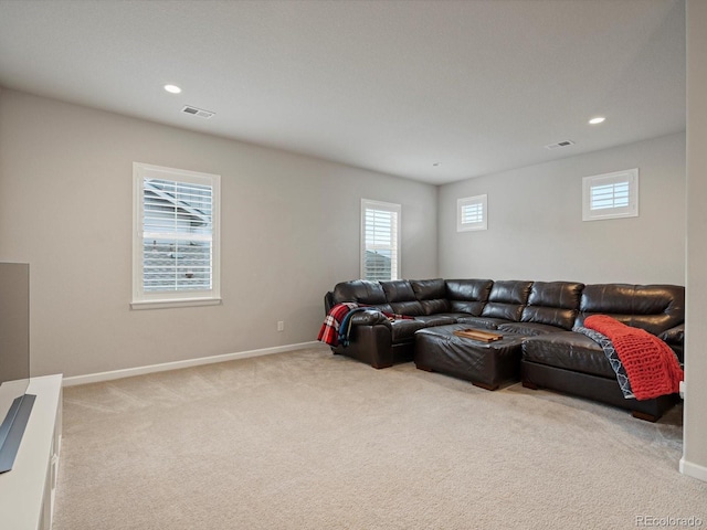 living area featuring light carpet, a wealth of natural light, and baseboards