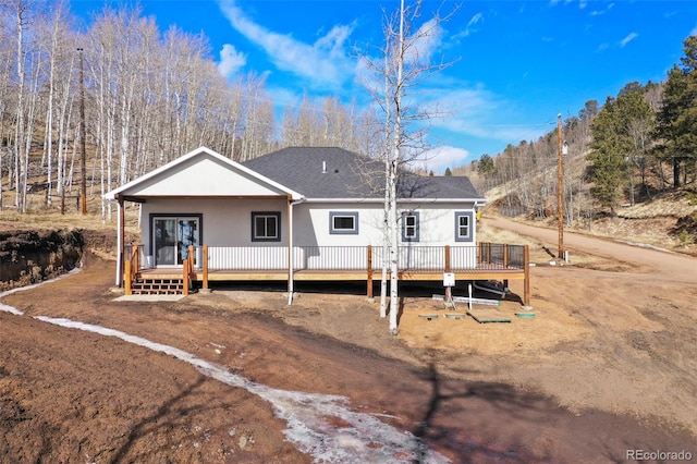 rear view of house with a wooden deck and a porch