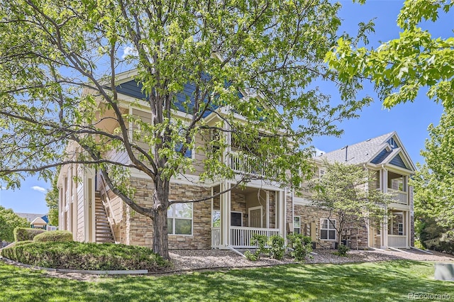3375 Boulder Cir Unit 204, Broomfield, CO 80023 - view of front facade with stone siding, a front lawn, and a balcony