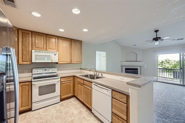 3375 Boulder Cir Unit 204, Broomfield, CO 80023 - kitchen featuring white appliances, a sink, a peninsula, recessed lighting, and a tile fireplace