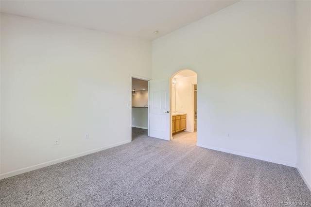 3375 Boulder Cir Unit 204, Broomfield, CO 80023 - unfurnished room featuring arched walkways, light colored carpet, baseboards, and high vaulted ceiling