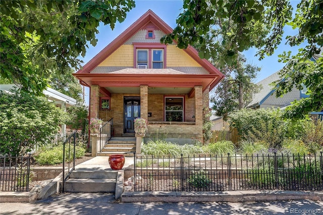 1316 S Pearl St, Denver, CO 80210 - view of front of home featuring a porch, a fenced front yard, and brick siding