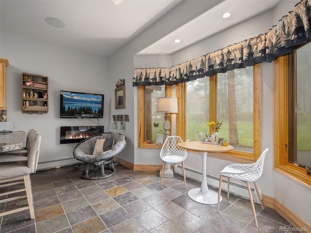 23076 Oehlmann Park Rd, Conifer, CO 80433 - sitting room with baseboard heating, stone tile flooring, a glass covered fireplace, and recessed lighting