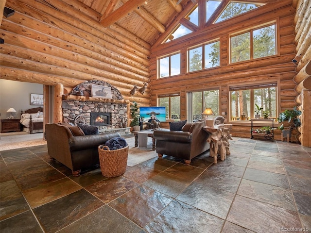 23076 Oehlmann Park Rd, Conifer, CO 80433 - living area featuring high vaulted ceiling, stone tile floors, healthy amount of natural light, a fireplace, and a wooden ceiling with exposed beams