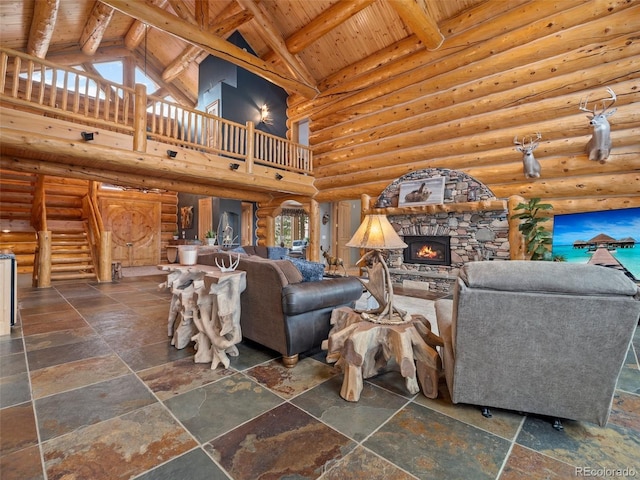 23076 Oehlmann Park Rd, Conifer, CO 80433 - living room featuring high vaulted ceiling, a wood ceiling with exposed beams, stone tile flooring, a stone fireplace, and stairs