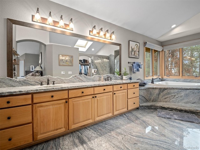 23076 Oehlmann Park Rd, Conifer, CO 80433 - full bath with vaulted ceiling, a garden tub, double vanity, marble tiled flooring, and recessed lighting