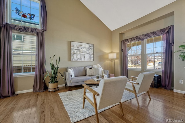 living area with plenty of natural light, hardwood / wood-style flooring, and baseboards