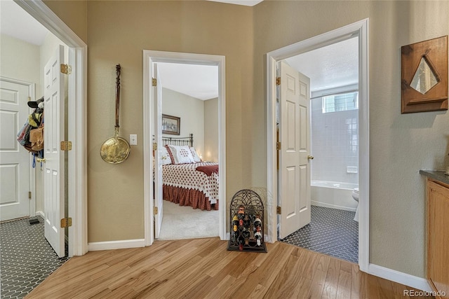 corridor with light wood-style flooring and baseboards