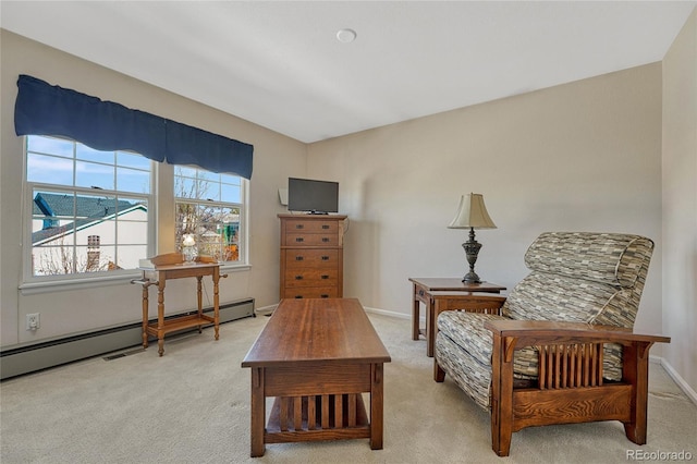 living area featuring a baseboard heating unit, baseboards, and light colored carpet