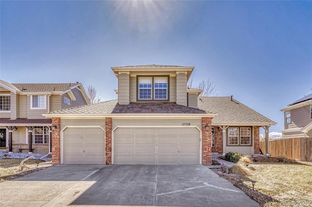 view of front of house featuring a garage, driveway, brick siding, and fence