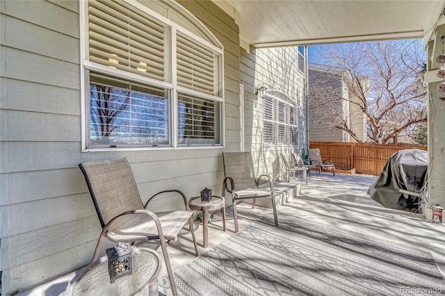 wooden terrace featuring fence and a grill