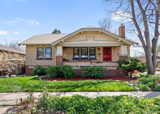3242 Utica St, Denver, CO 80212 - view of front of property with brick siding, a porch, a chimney, and a front yard