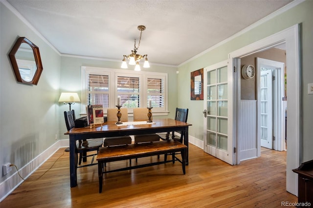 3242 Utica St, Denver, CO 80212 - dining area featuring a chandelier, ornamental molding, light wood-type flooring, and baseboards