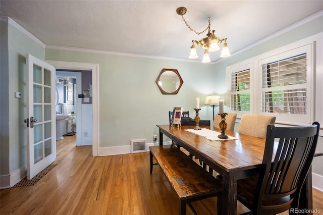 3242 Utica St, Denver, CO 80212 - dining area featuring a chandelier, baseboards, light wood-style floors, french doors, and ornamental molding
