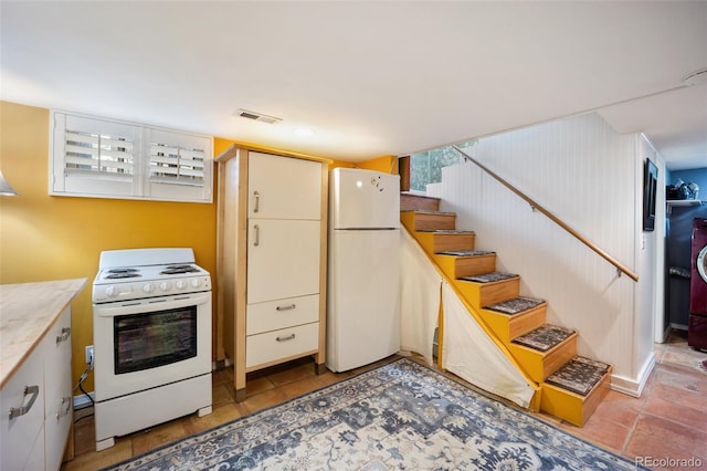 3242 Utica St, Denver, CO 80212 - kitchen featuring white appliances, light countertops, light tile patterned floors, and cream cabinets