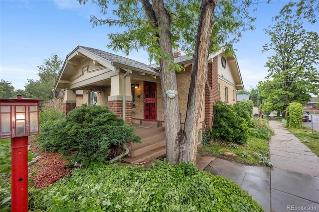 3242 Utica St, Denver, CO 80212 - view of front of property with brick siding, a porch, and roof with shingles
