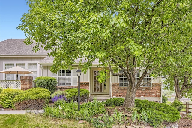 2980 W Long Dr Unit E, Littleton, CO 80120 - view of property hidden behind natural elements featuring brick siding, board and batten siding, and a shingled roof