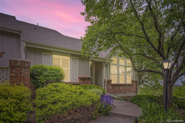 2980 W Long Dr Unit E, Littleton, CO 80120 - doorway to property featuring board and batten siding, brick siding, and roof with shingles