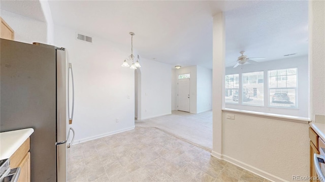 unfurnished dining area featuring ceiling fan, a chandelier, and baseboards