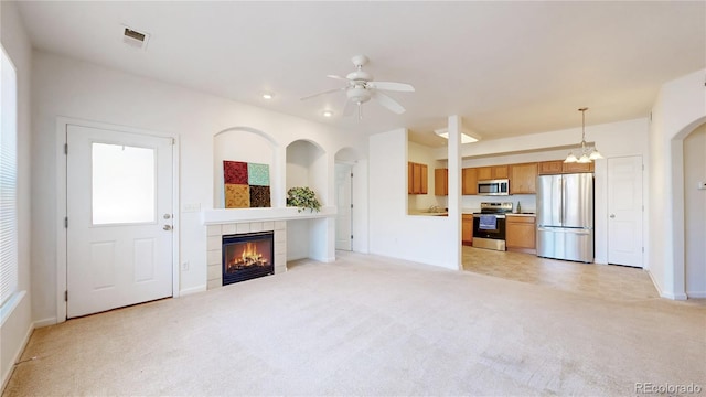 unfurnished living room with light colored carpet, a fireplace, ceiling fan, baseboards, and recessed lighting