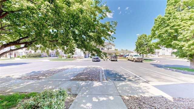 view of asphalt street with sidewalks, a residential view, and curbs