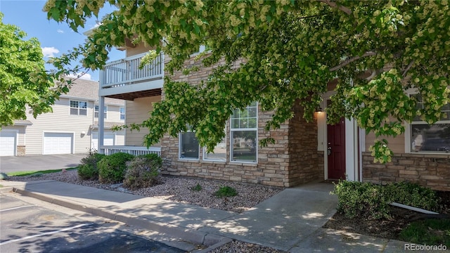 view of front of property featuring a balcony and stone siding