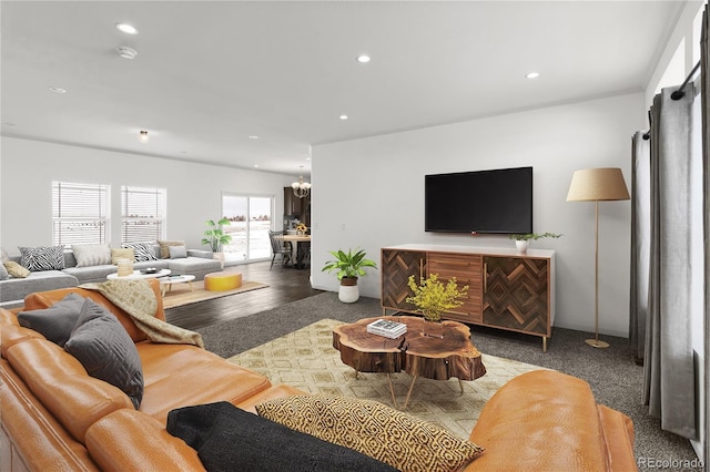 carpeted living room featuring a notable chandelier