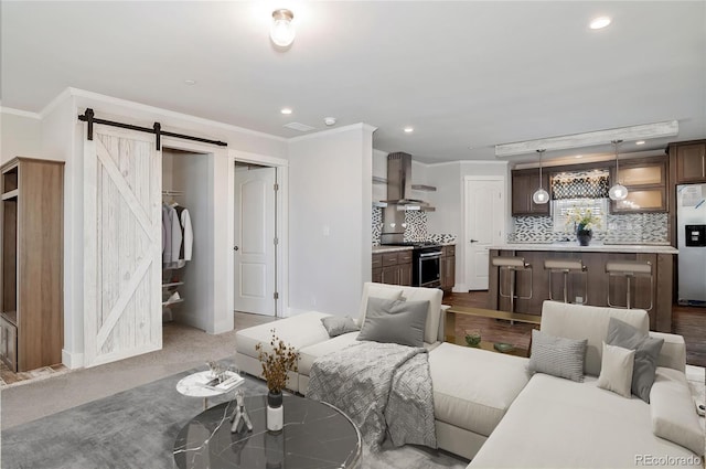 living room featuring carpet, a barn door, and crown molding