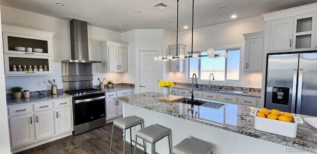 60600 E 56th Ave, Strasburg, CO 80136 - kitchen with wall chimney range hood, stainless steel appliances, hanging light fixtures, and white cabinets