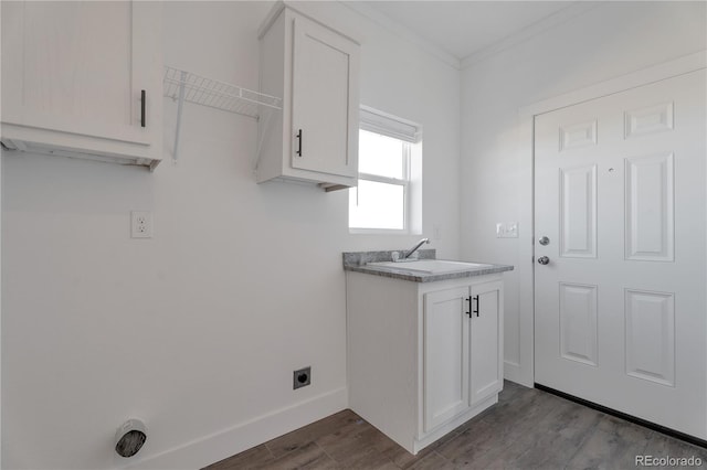 washroom with sink, crown molding, hardwood / wood-style floors, cabinets, and hookup for an electric dryer