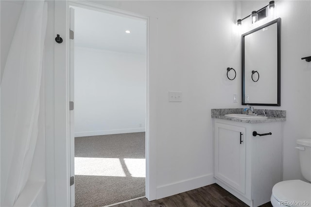 bathroom with vanity, toilet, and wood-type flooring