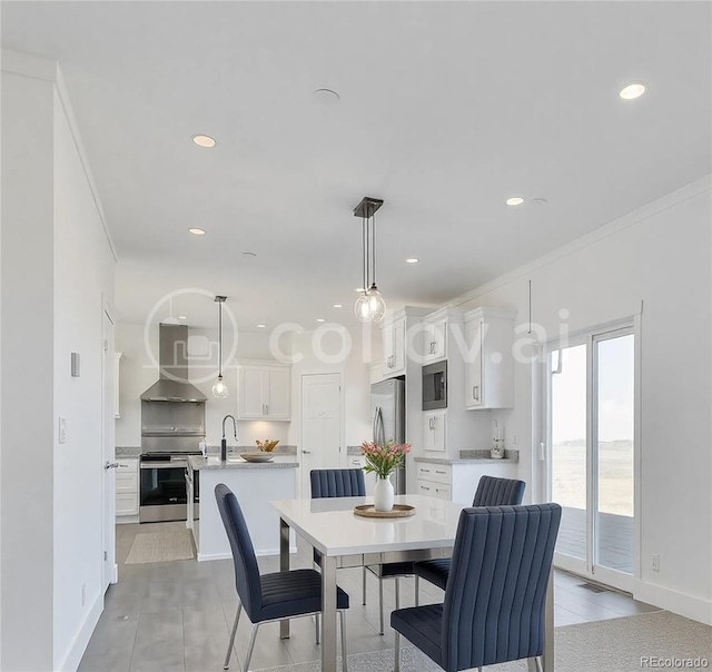 tiled dining room featuring sink and crown molding