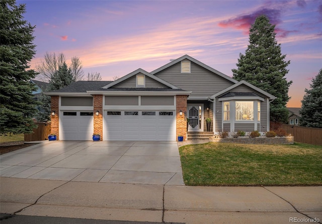 view of front of property with a front yard, an attached garage, fence, concrete driveway, and brick siding