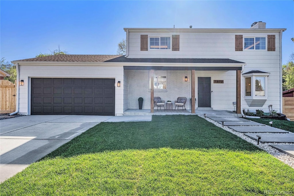 5872 Taft St, Arvada, CO 80004 - traditional home with concrete driveway, a front yard, a porch, and an attached garage