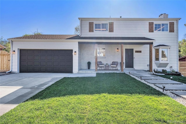 traditional home with concrete driveway, a front yard, a porch, and an attached garage