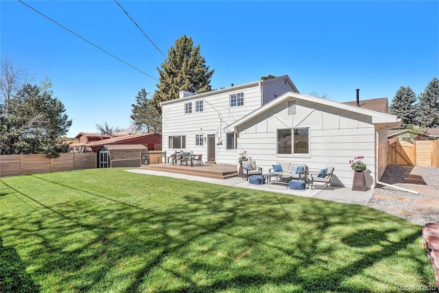 rear view of property with a shed, an outdoor structure, an outdoor hangout area, a deck, and a fenced backyard