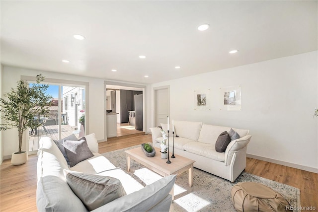 living room featuring baseboards, light wood-style floors, and recessed lighting
