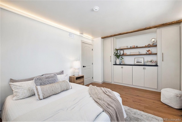 bedroom with light wood-style flooring and visible vents