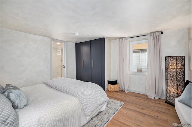 bedroom with light wood-style flooring and baseboards